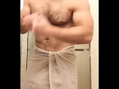 Hairy muscle bear flexing before shower